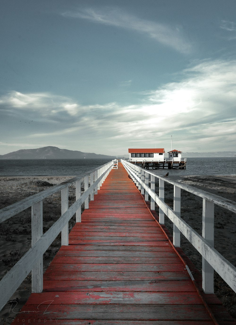 a wooden walkway leading to a building on a beach