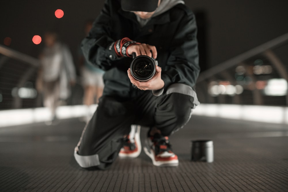 a man kneeling down holding a camera