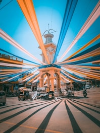 A vibrant collage showing transport vehicles, digital devices, and pilgrims in motion under a clear sky.