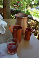 A set of antique gold accented copper mugs arranged on a royal black velvet cloth.