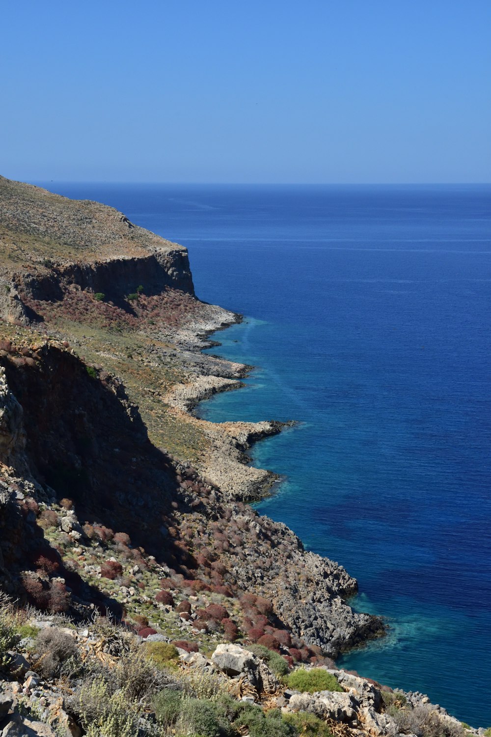 a rocky cliff next to a body of water