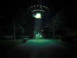 An artist’s rendering of a historic UFO landing site with silhouetted figures nearby.