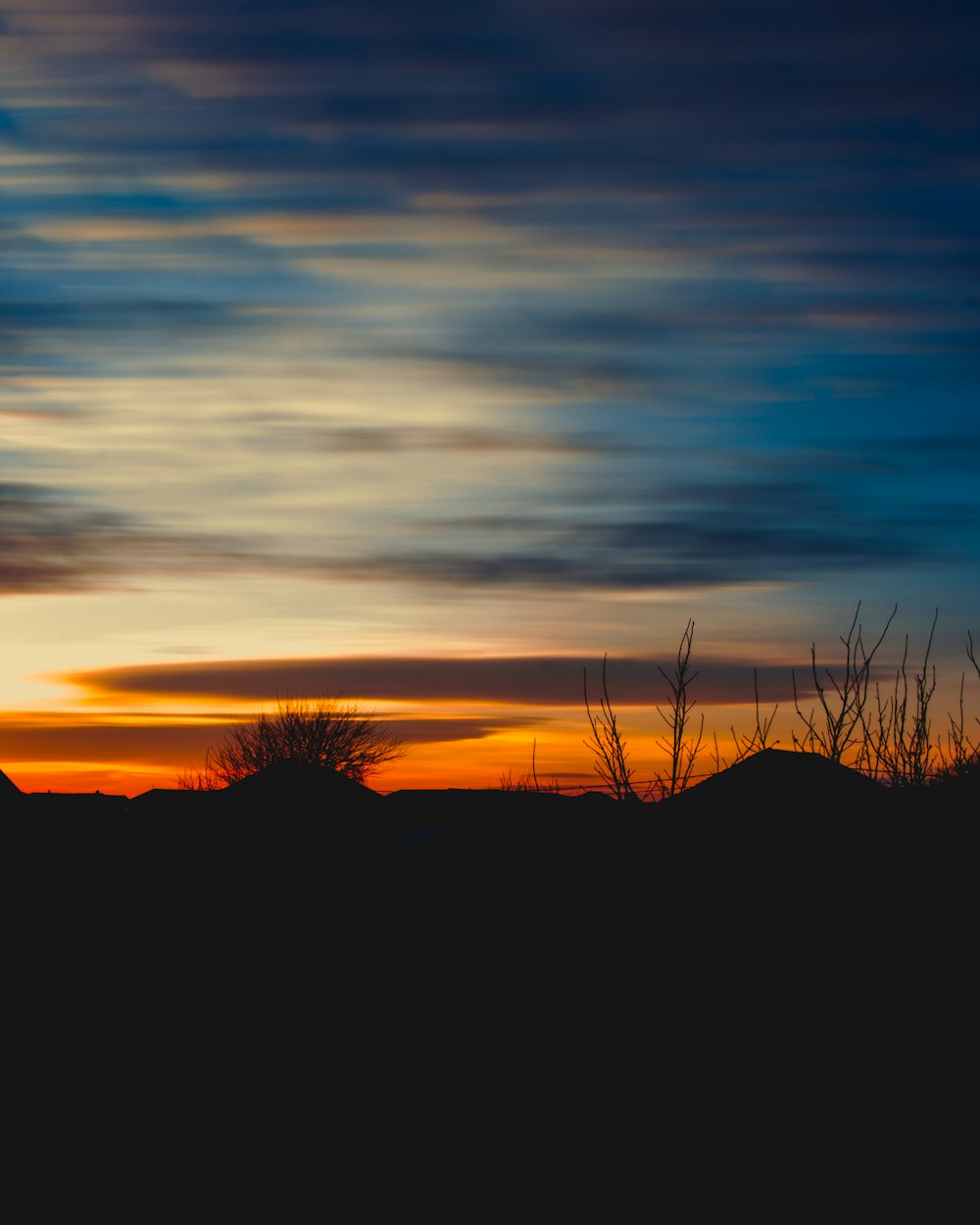 a sunset over a hill