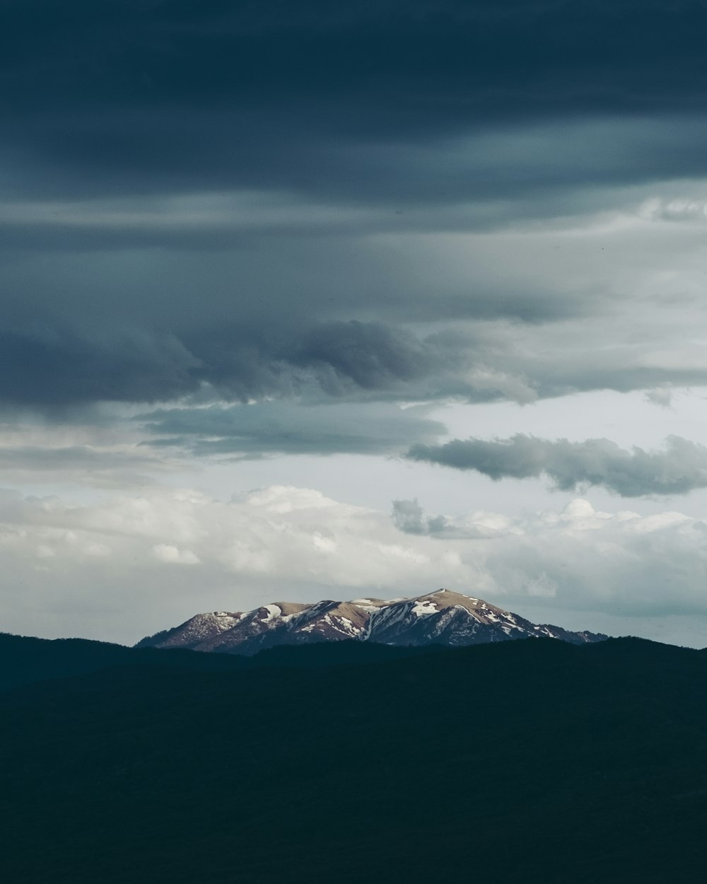 a mountain with clouds above it