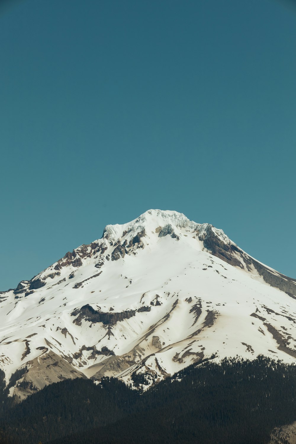 a snowy mountain with a blue sky