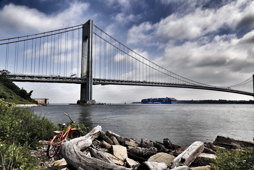 a bicycle on a rock by a bridge