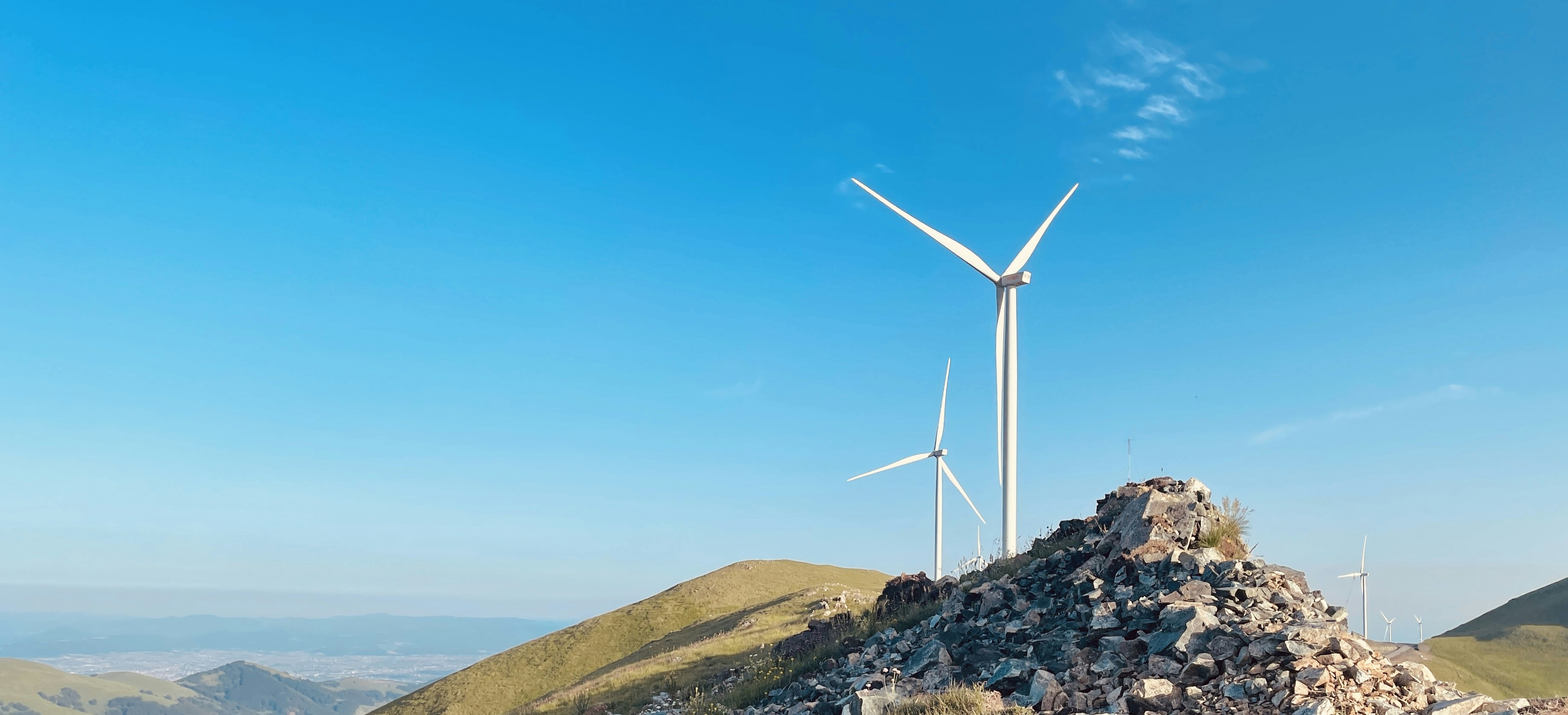 a group of wind turbines on a hill