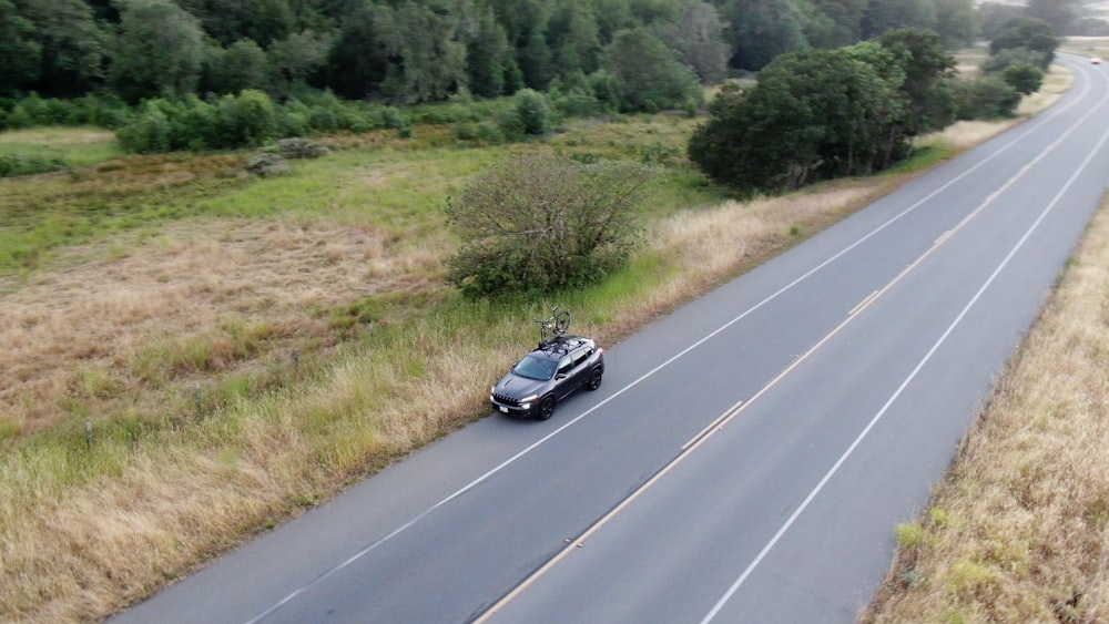 a black car driving down a road