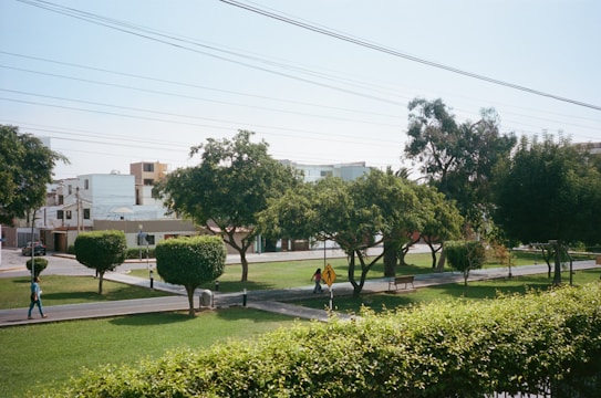A community park with families enjoying walking paths and green lawns.