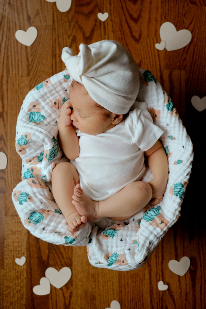 A baby sleeping peacefully on a blanket — Thalam Studio newborn photography.