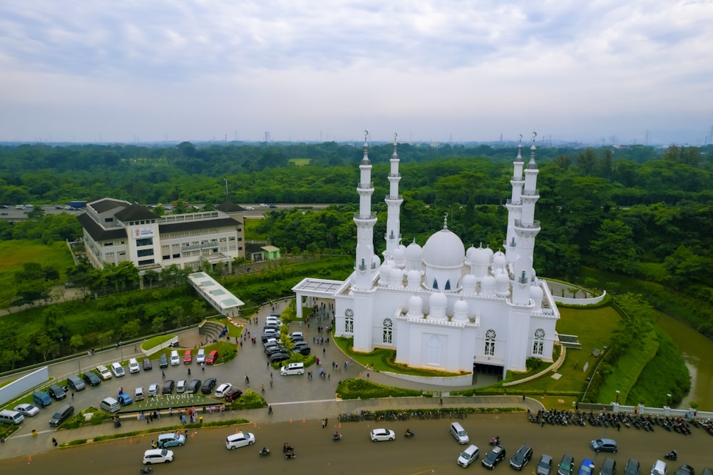 a large white building with towers and domes surrounded by trees