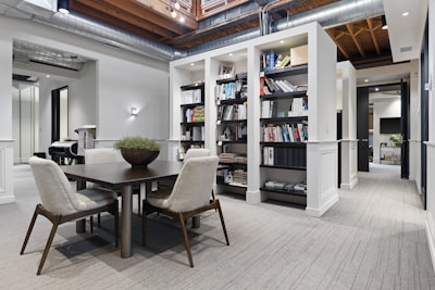 a room with a table chairs and a bookcase