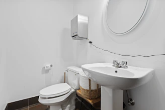 a bathroom with a sink toilet and mirror