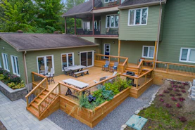 a deck with chairs and tables on it and a deck with plants