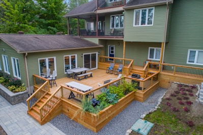 a deck with chairs and tables on it and a deck with plants