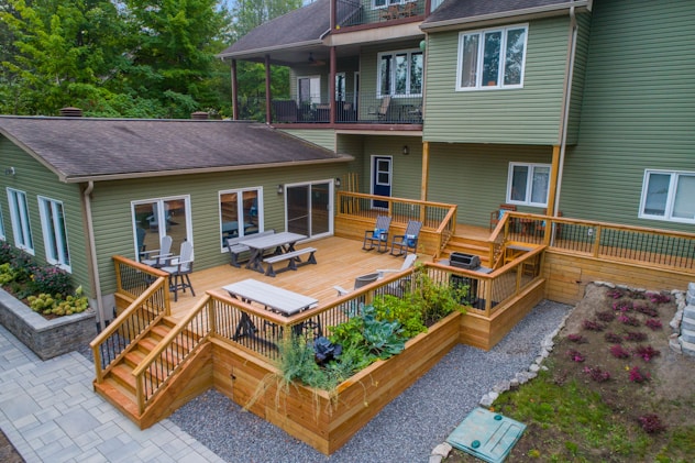 a deck with chairs and tables on it and a deck with plants