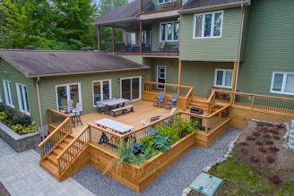 a deck with chairs and tables on it and a deck with plants
