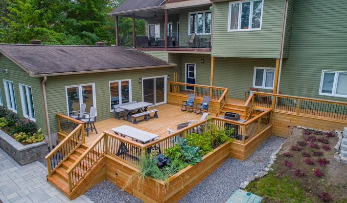 a deck with chairs and tables on it and a deck with plants
