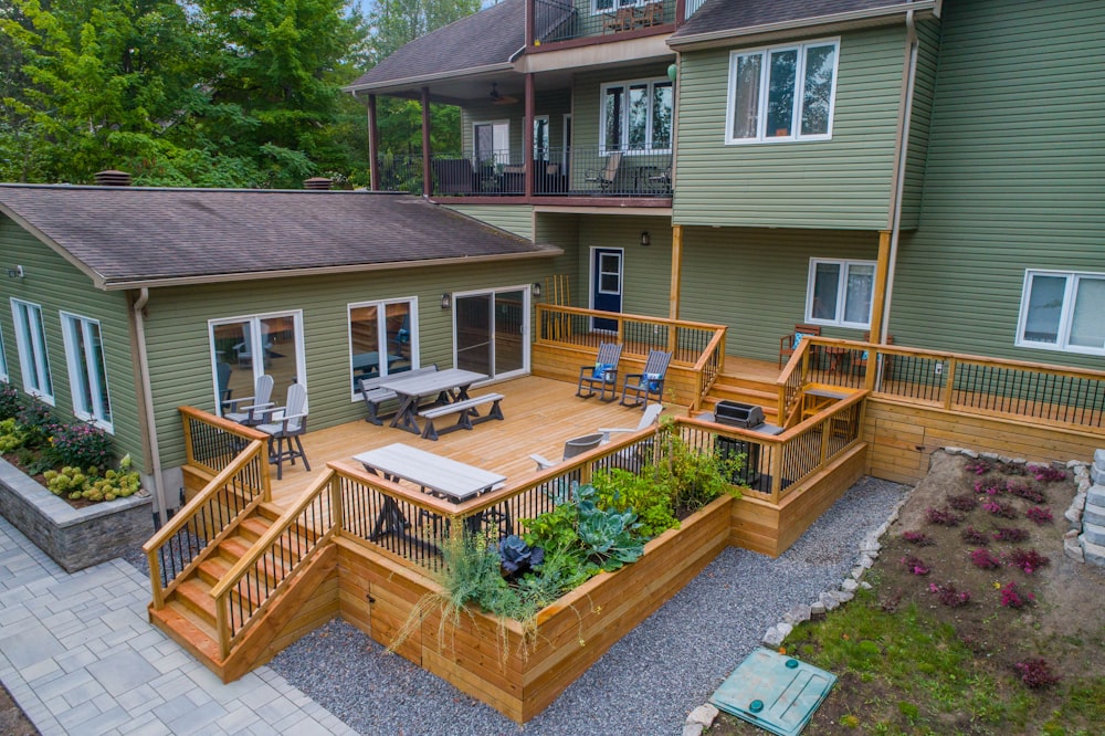 a deck with chairs and tables on it and a deck with plants