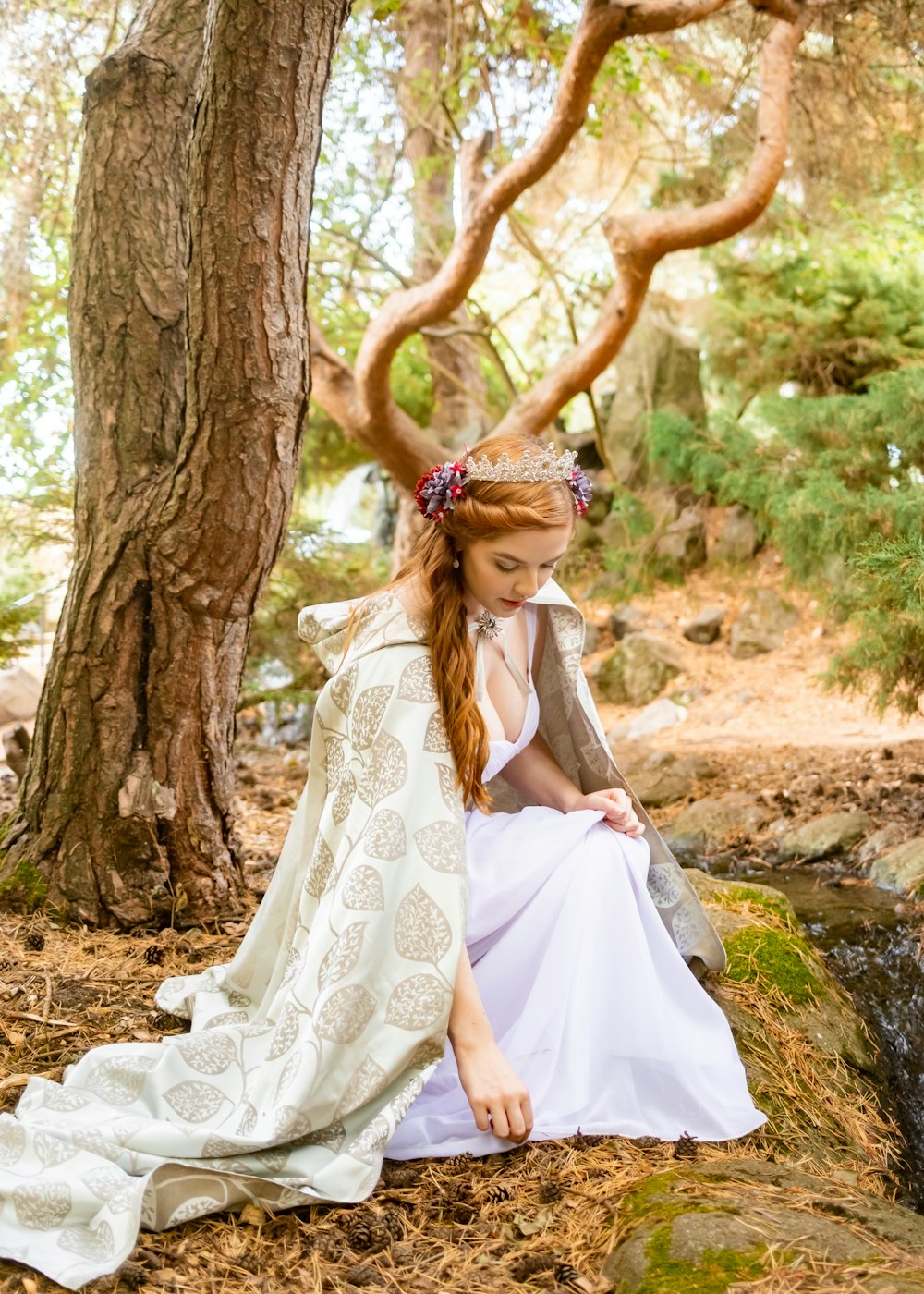 a person in a white dress sitting on a tree