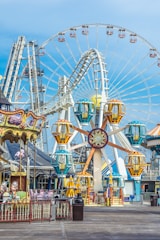 a ferris wheel with a blue sky with Coney Island in the background