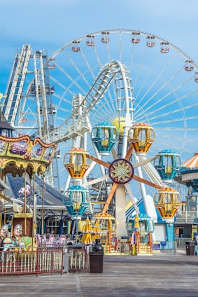 a ferris wheel with a blue sky with Coney Island in the background