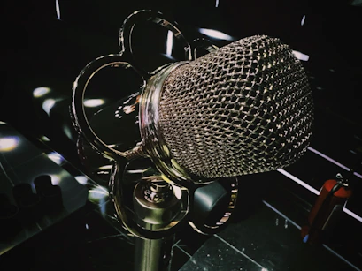 A close-up of a vintage microphone glowing with cinematic shadows.