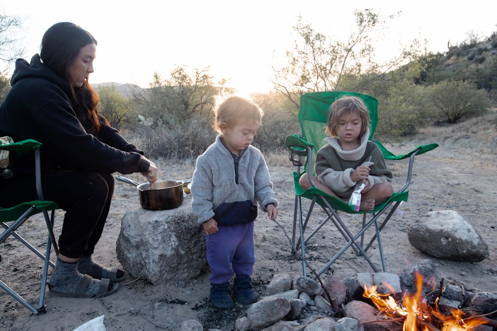 a person and a child by a fire pit with a person and a child sitting in a chair