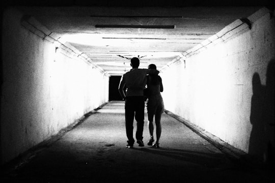 a man and a woman walking in a tunnel