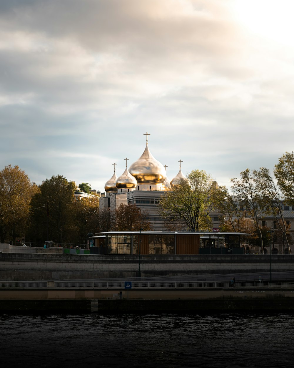 a building with a gold domed roof by a river