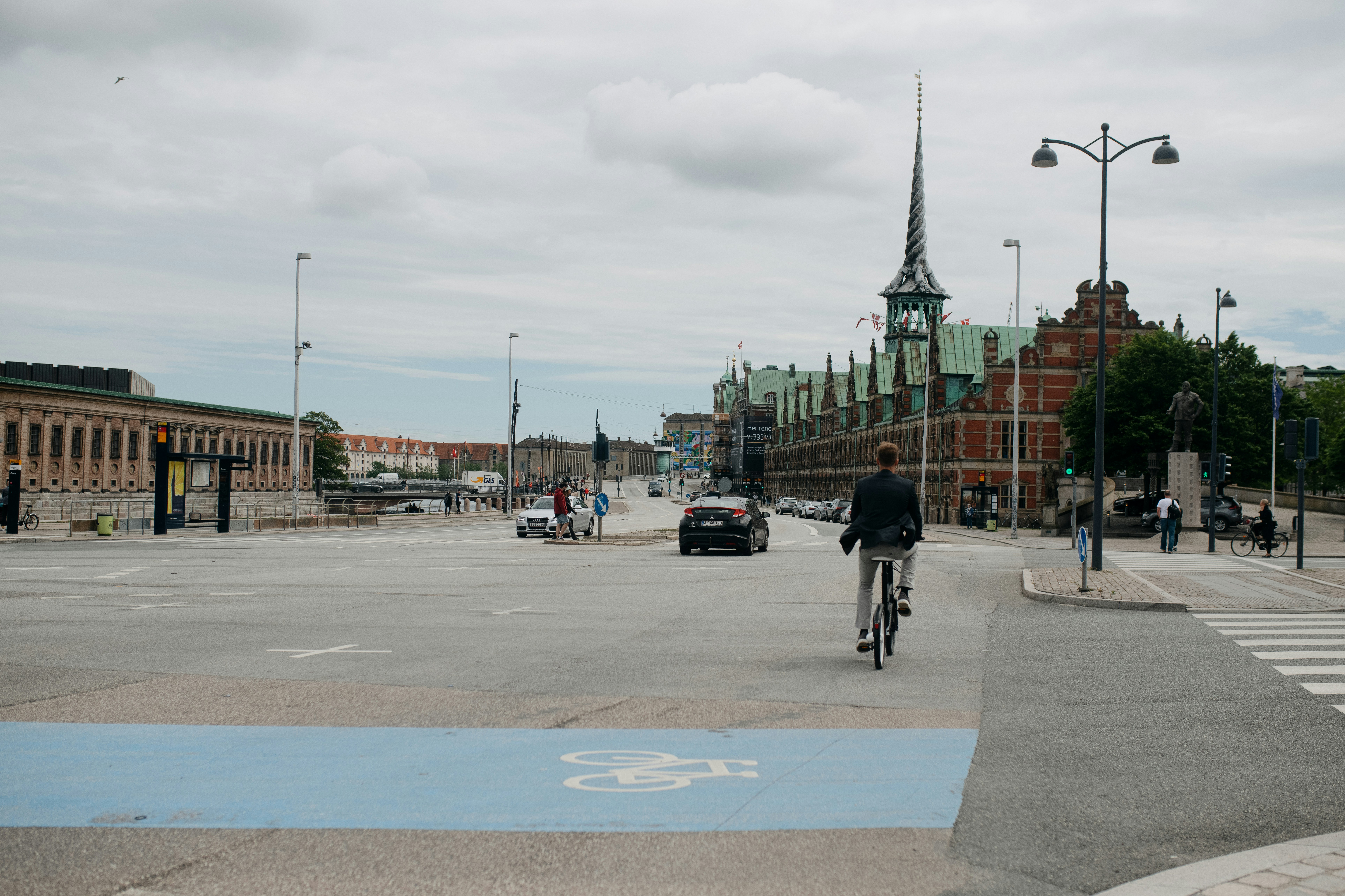 a person riding a bicycle on a street with a building in the background