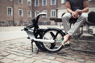 a person sitting on a bench next to a bicycle