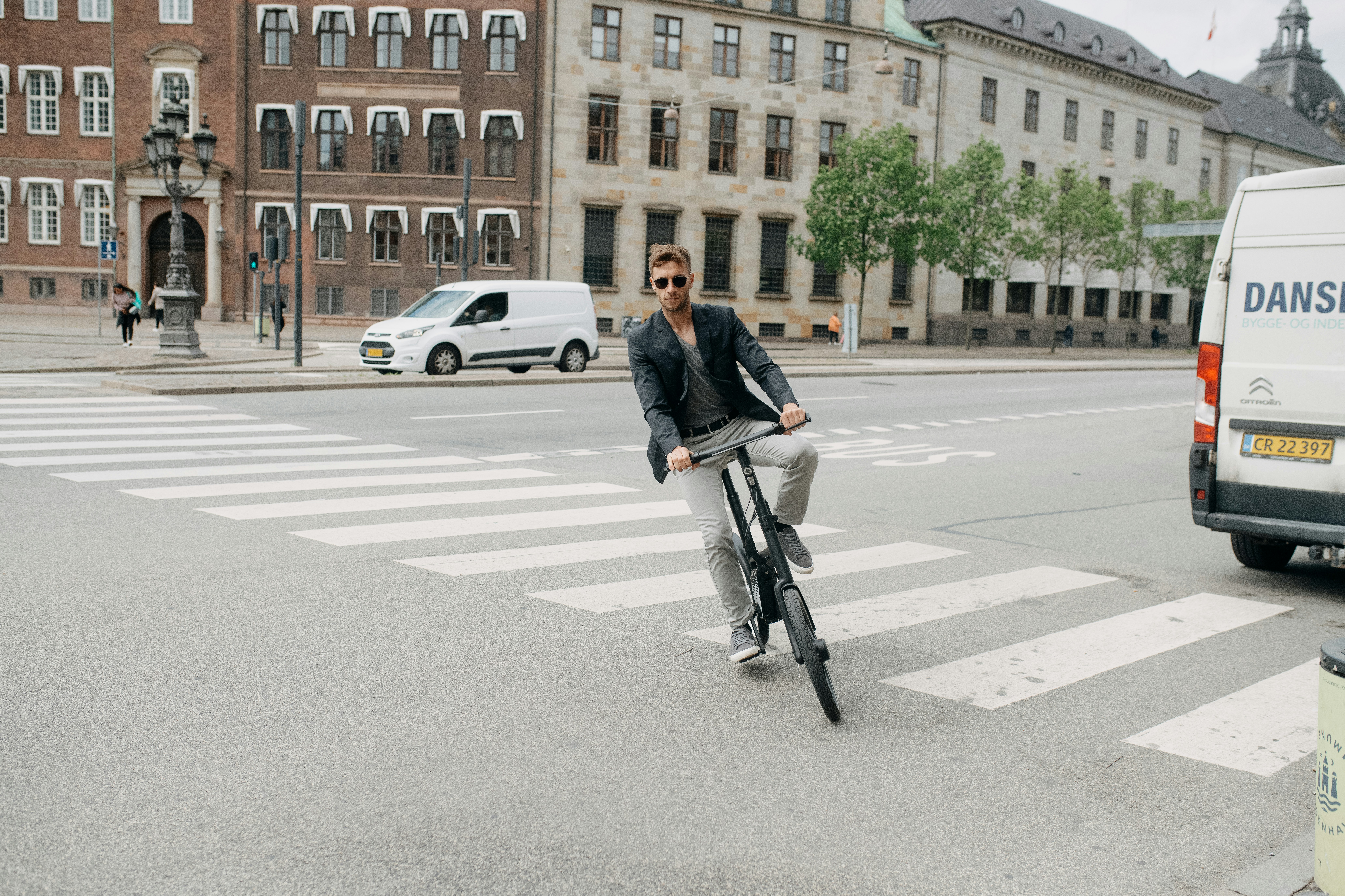 A person riding a bicycle across a crosswalk photo – Free Honbike Image ...