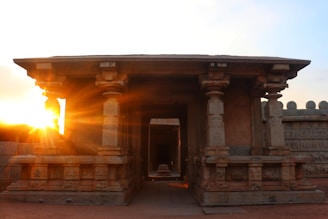 An ancient temple carved from sandstone, bathed in the warm glow of sunset.