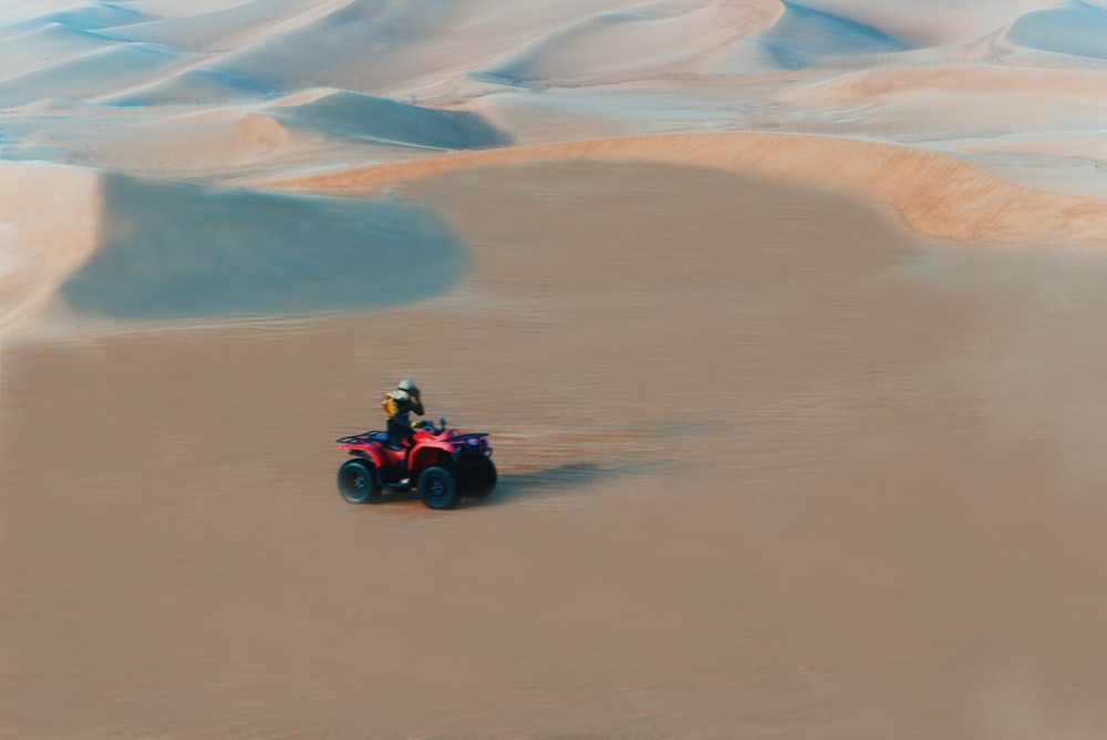 a person driving a red vehicle in the desert