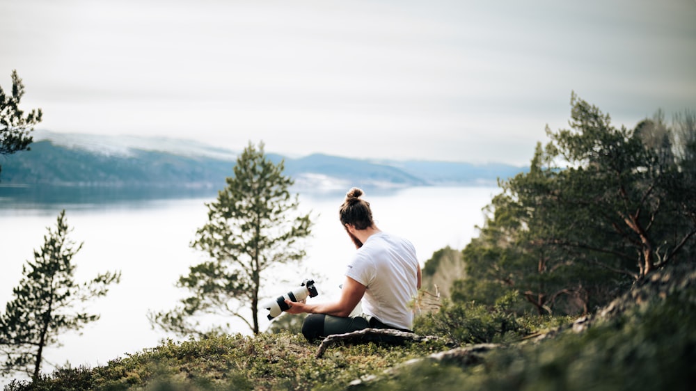 a man sitting on a rock overlooking a body of water