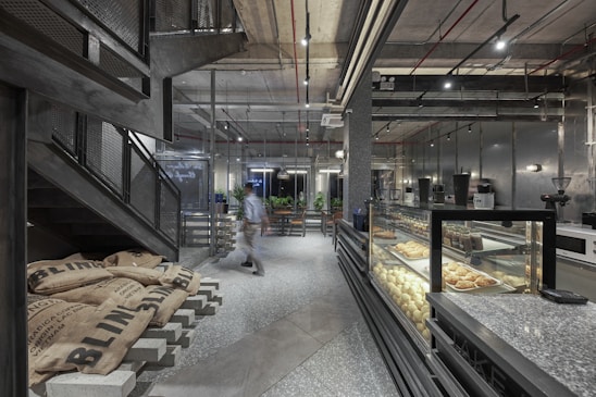 a person walking in a large room with food on display