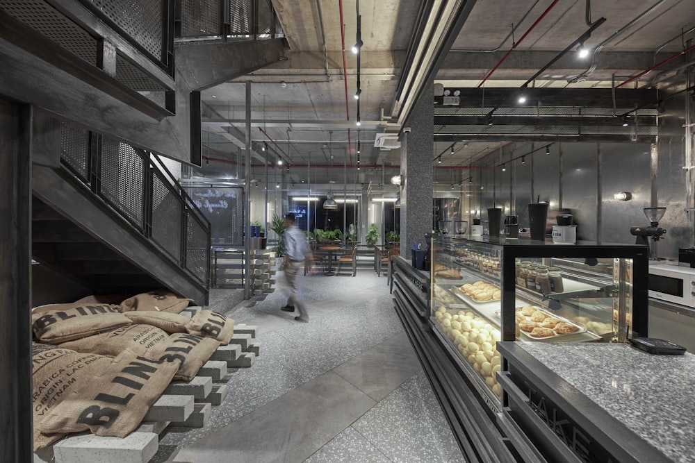 a person walking in a large room with food on display