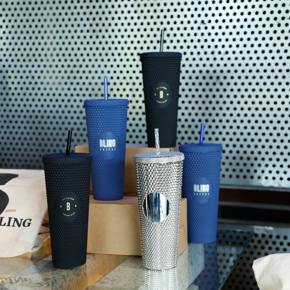 a group of cups with blue straws on a table