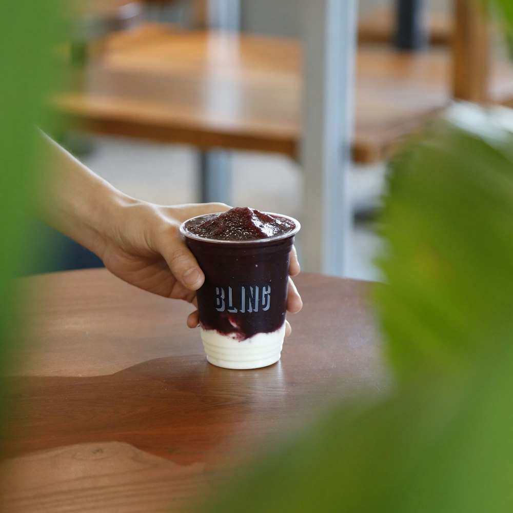 a hand holding a cup of coffee