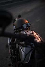 Close-up of a rugged motorcycle helmet resting on a vintage bike seat under soft natural light.