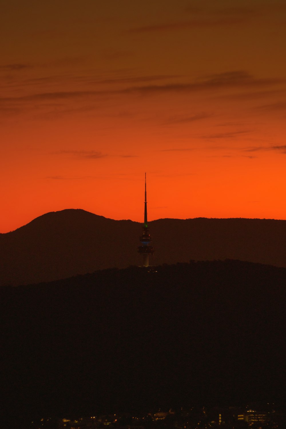 a tower in the middle of a city at sunset