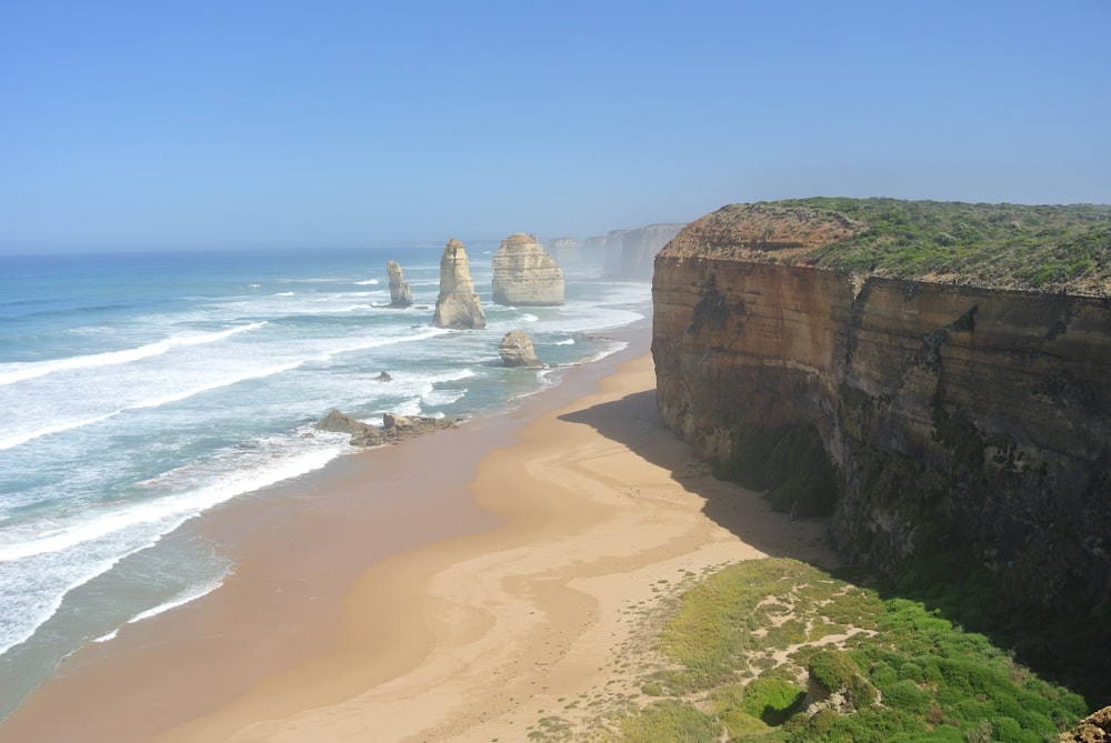 a beach with a cliff and water