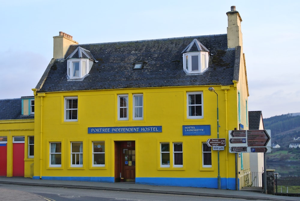 a yellow building with a black roof