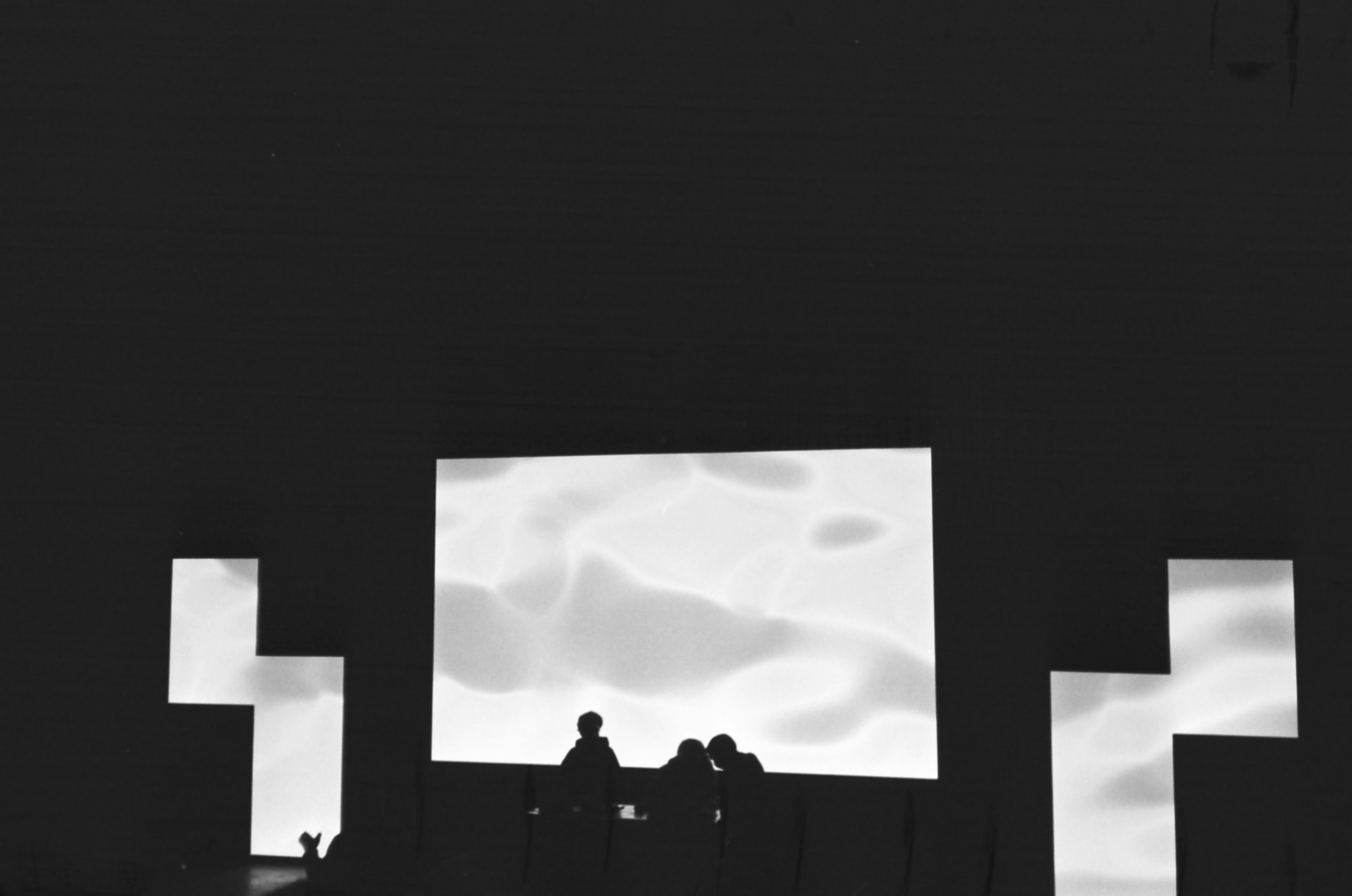 a group of people looking at a large screen