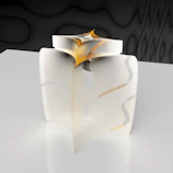 Handmade resin sculpture with subtle golden hues displayed on a smooth, creamy surface.