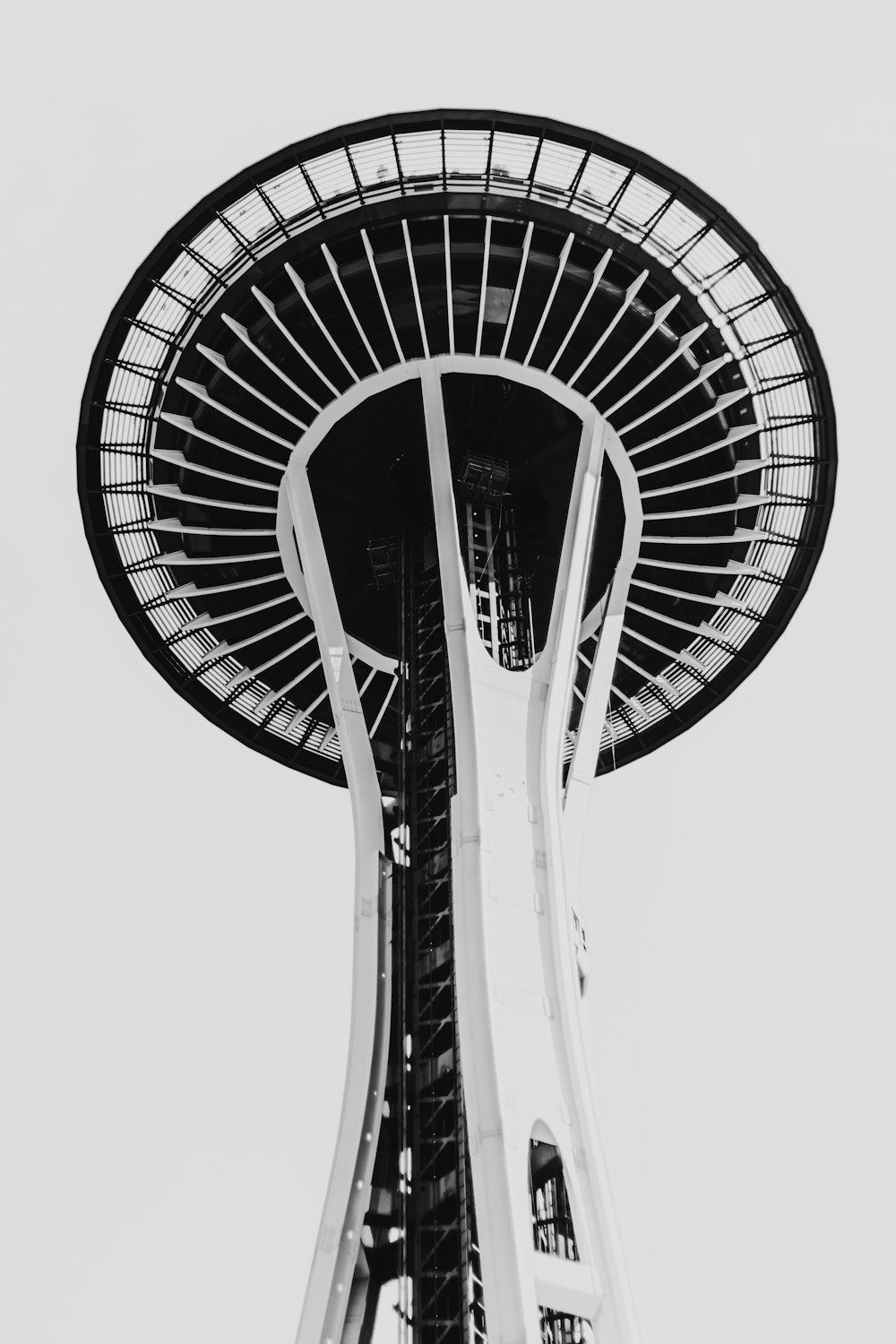 a tall tower with a circular top with Space Needle in the background