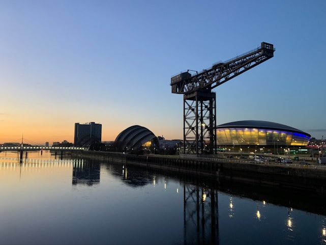 A sleek navy blue and gold-themed legal scale balanced over the Austin city skyline at dusk