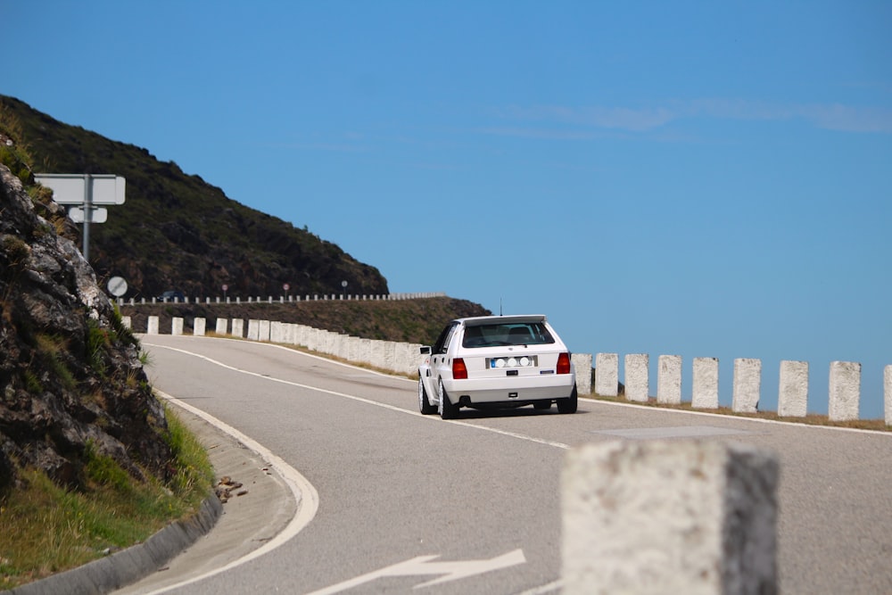 a white car driving on a road