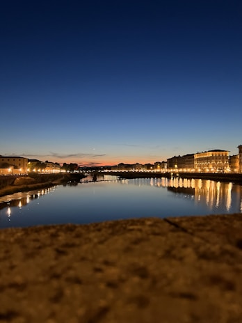 A serene view of Durgapur Barrage with calm waters reflecting the sky at sunset.